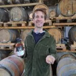 Etienne d'Hautefeuille tenant une bouteille de whisky