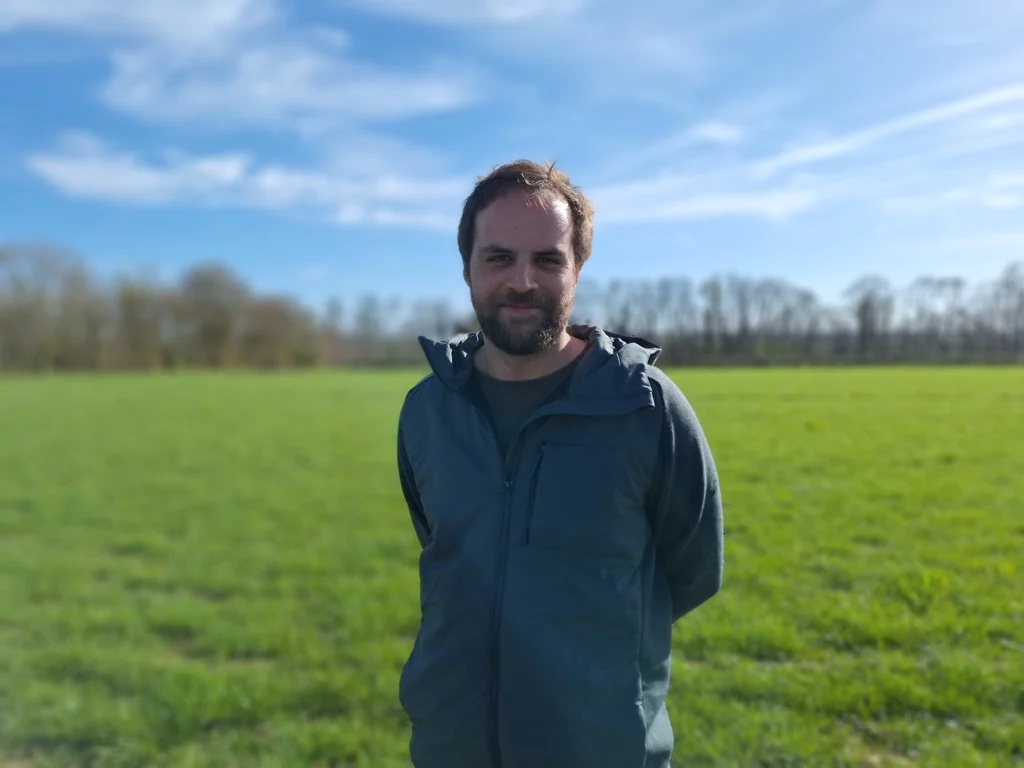 Homme dans une prairie verte par une journée ensoleillée